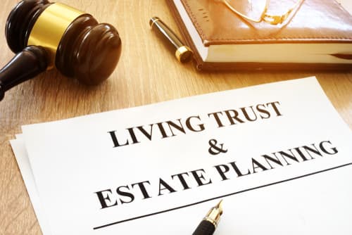 living trust and estate planning paper on desk with gavel, book, and pen
