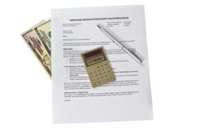 Mortgage modification form with calculator and pen on white background