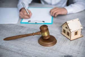 Lawyer hand document with judge and house model on table