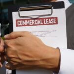 A business owner is holding a commercial lease agreement in his hand