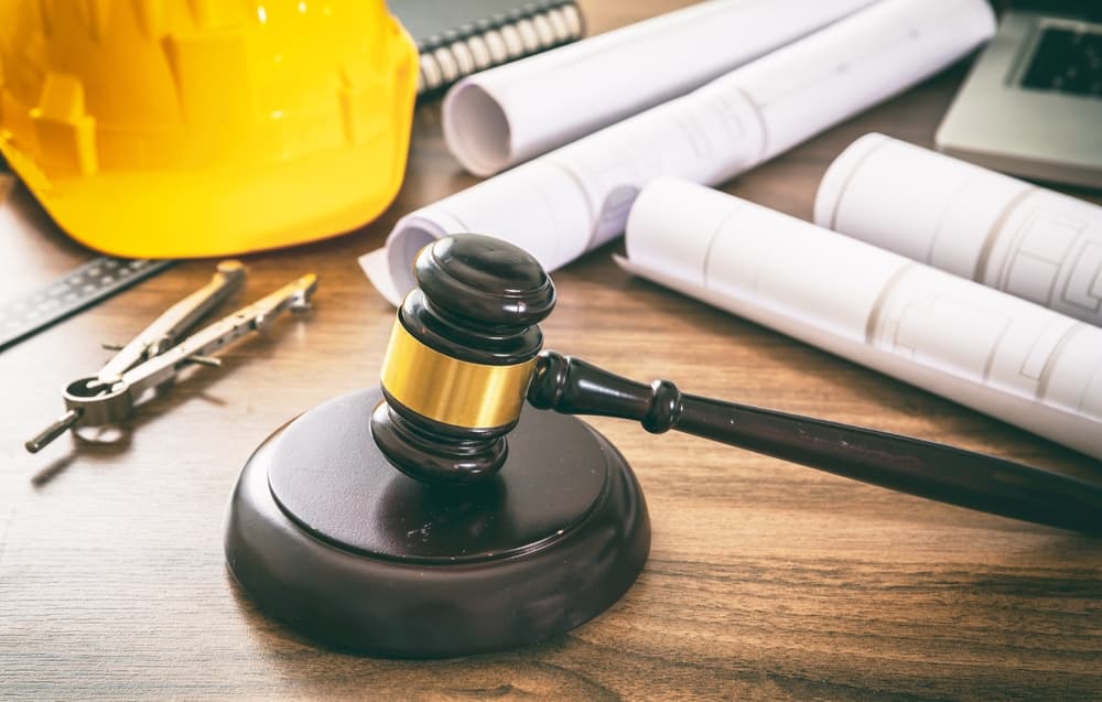 Judge gavel and building drawings on wooden table
