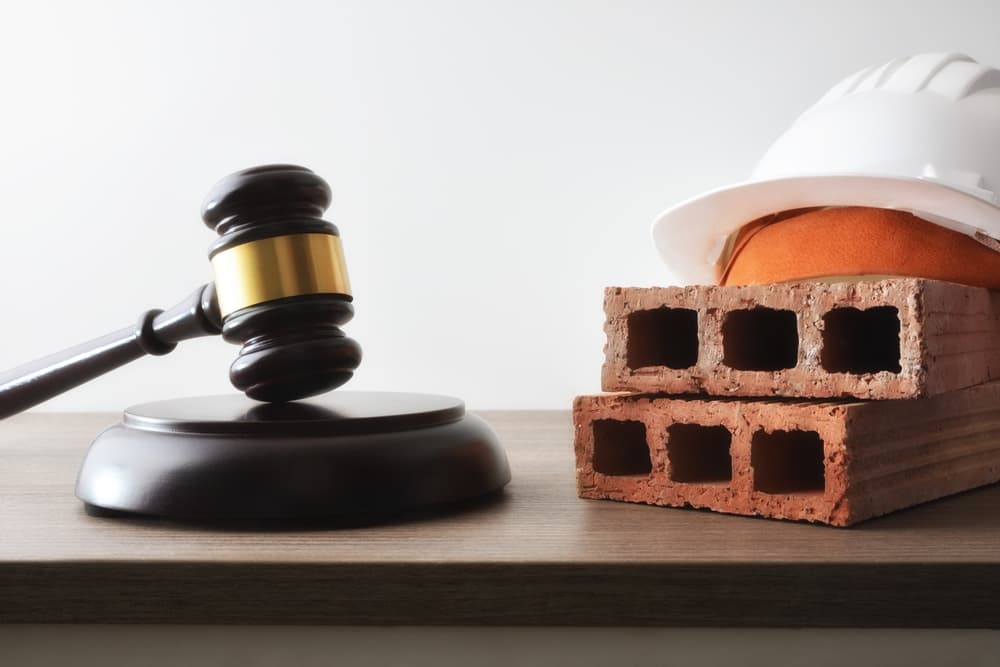 construction concept: judge's gavel and bricks with protective helmet 